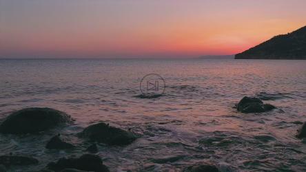 太阳落山时，海浪拍打着岩石[]