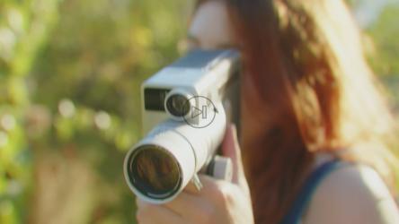 女人透过老式8毫米相机的镜头看[]