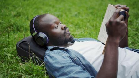 男子在公园边听音乐边看书[4K]