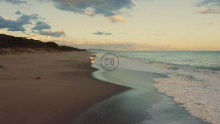 日落时在海边行驶的汽车[]