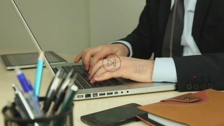 一名男子坐在沙发上用笔记本电脑工作[]