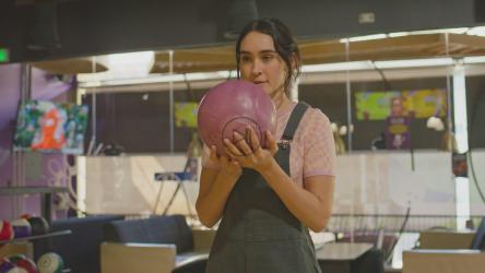 一位年轻的深色头发女子庆祝保龄球比赛[免费商用]