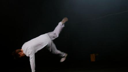 穿着白色衣服表演的年轻霹雳舞者[]