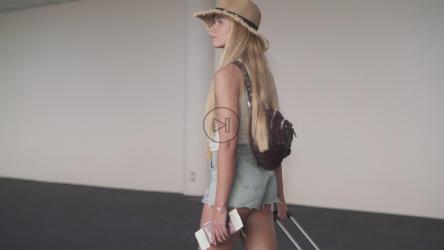 年轻女子拿着护照走在机场[]