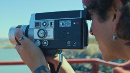 一个年轻人正在调整一台旧胶卷相机的镜头[免费商用]