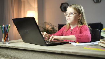 女孩在桌子旁的电脑上打字[4K]