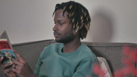 坐在沙发上听音乐看书的男人[4K免费商用]