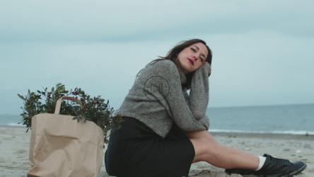 女孩坐在海滩上做白日梦[]