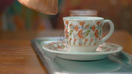 Turkish coffee being poured into a decorated cup[]
