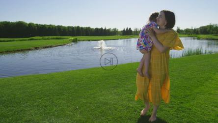 母亲和孩子在湖边的喷泉旁[]