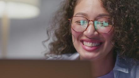 一位年轻女子在现场网络研讨会上微笑着向人们挥手致意[]