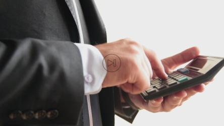 Businessman tallying on a calculator[]