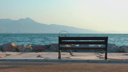 一名男子坐在长椅上眺望大海[]