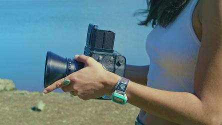 一位年轻女子用手拿着一台老式相机。[免费商用]