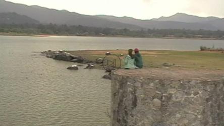 一对年轻夫妇坐在岩石结构上欣赏湖景[免费商用]