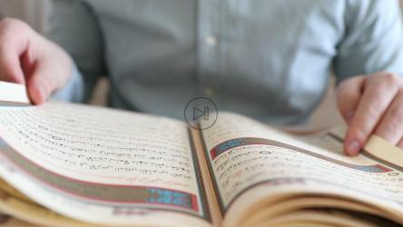 Person turning the sheets of the Quran[]
