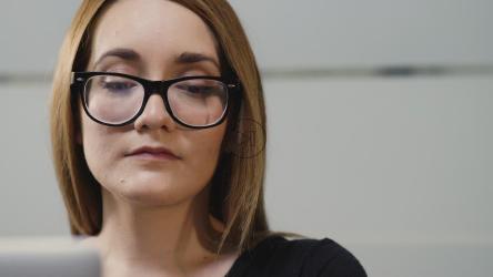 戴眼镜的年轻女子在笔记本电脑上工作[4K免费商用]