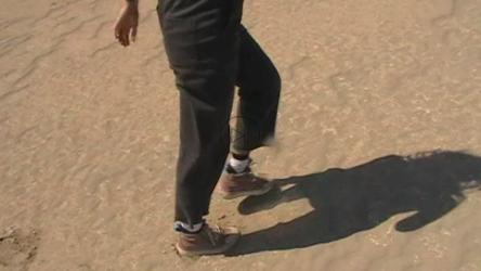 快乐的女孩走过阳光明媚的沙漠[免费商用]