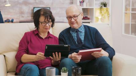 老年夫妇在沙发上用平板电脑享受视频通话[]