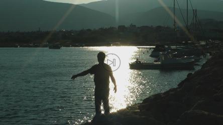 日出时在港口做伸展运动的男子[]