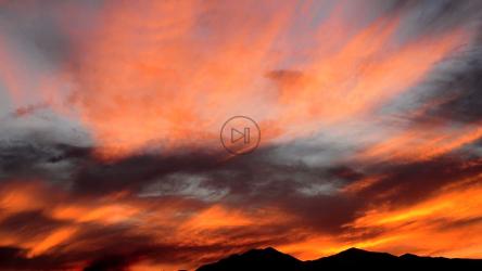 红色和橙色的日落在山上[]