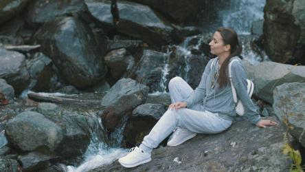 在森林中的瀑布旁放松的女人[4K]