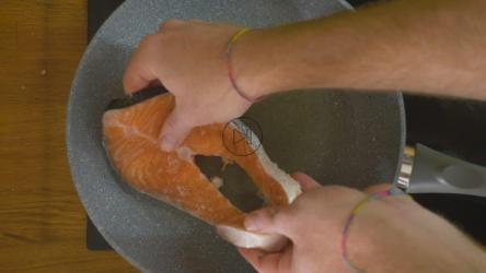 两块三文鱼牛排被放入滚烫的锅中[]