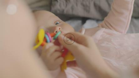 抱着塑料玩具的婴儿[]