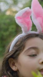 小女孩在花园灌木丛中寻找复活节彩蛋惊喜[免费商用竖屏]