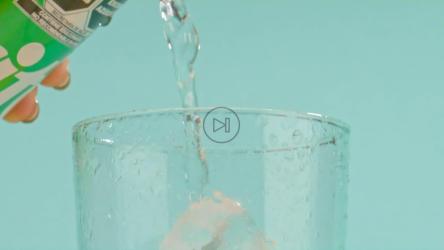 一只手拿着柠檬汽水，把冒泡的液体倒进杯子里[免费商用]