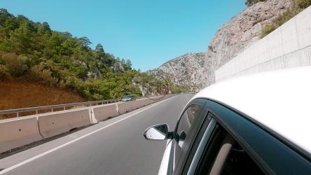 从车窗望出去，在山旁行驶[]