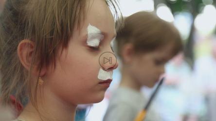 开始用面部彩绘画一个年轻女孩的脸[]