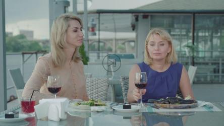 服务员给在户外餐厅用餐的女士送外卖袋[]