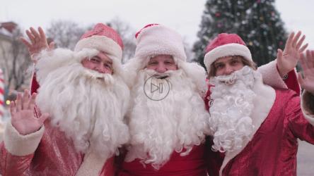 三个有趣的圣诞老人在圣诞节对着镜头挥手[]