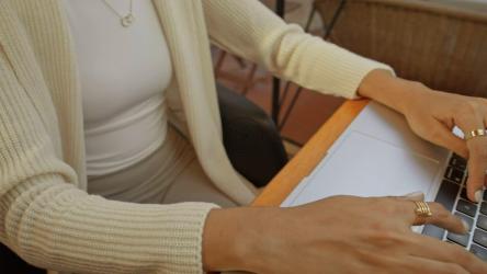 一位女士在电脑上工作时的桌子视图[免费商用]