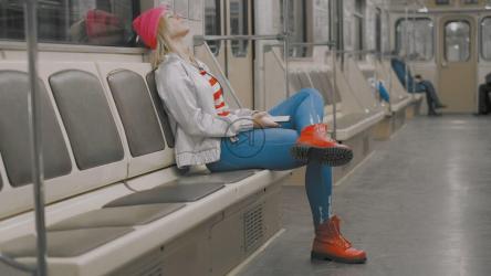 疲惫的年轻女子坐在地铁里听音乐[]