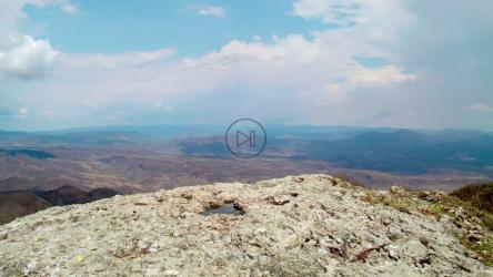 一个拿着专业相机的年轻人走到山边[免费商用]