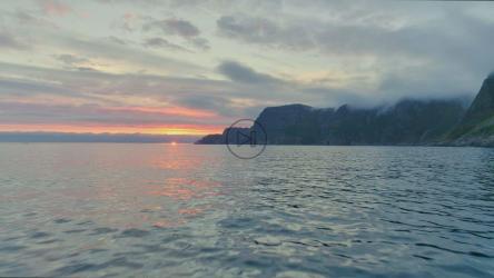 日落时分沿着山脉海岸飞越大海[]