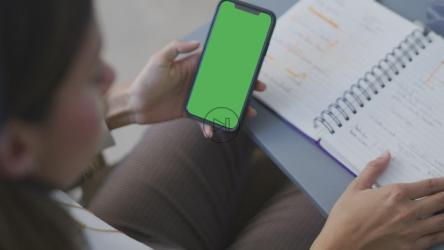 商务女性拿着一部绿色屏幕的手机[4K免费商用]