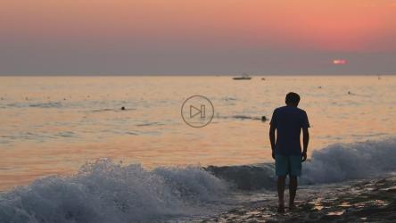 日落时海边的沮丧男子[]