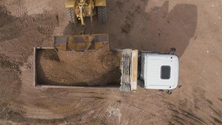 铲斗装载机向装载机倾倒泥土的鸟瞰图[]