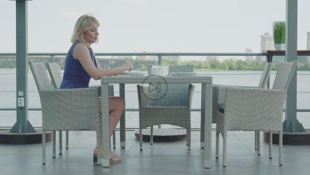 紧张的女人独自在户外餐厅等候[]