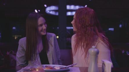 女人亲吻朋友；餐厅里的额头[]