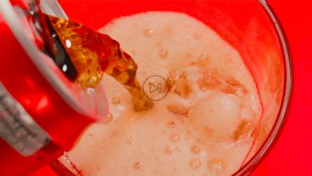 将一罐红色的可乐倒入加冰的玻璃杯中会产生苏打气泡[免费商用]