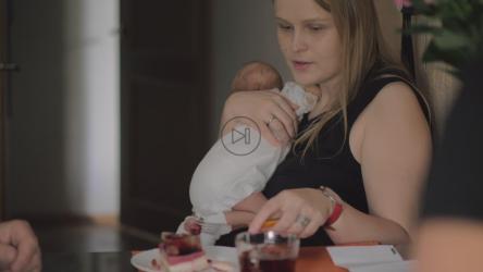 抱着孩子吃早餐的女人[]