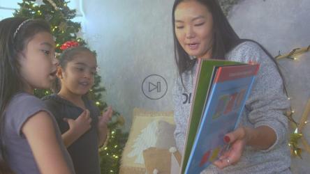 母亲在圣诞节和她的两个女儿一起看书[免费商用]