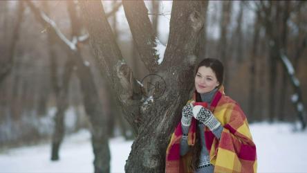 女人在冬天的森林里享受热饮[]
