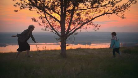 男孩和他的祖母在树旁玩耍[]