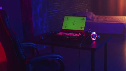 黑暗昏暗的房间里，游戏笔记本电脑的绿色屏幕[]