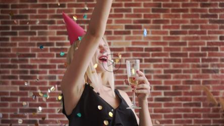 戴着派对帽子的快乐女人用香槟庆祝[]